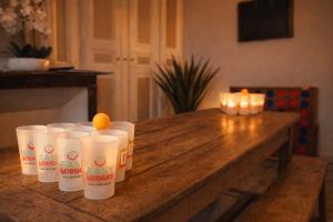 a group of cups sitting on top of a wooden table at Gîte Famille Amis Jeux XXL Paris in Vauchamps