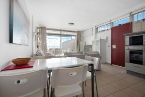a kitchen and dining room with a white table and chairs at Casa Médano 17 in Granadilla de Abona +21 photos