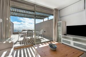 a living room with a view of a balcony with a television at Casa Médano 17 in Granadilla de Abona