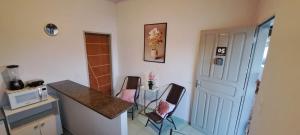 a kitchen with two chairs and a table and a counter at Flat JM 05 in Parauapebas