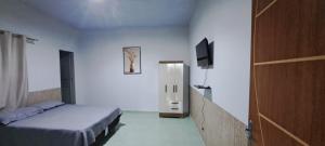 a bedroom with a bed and a television in it at Flat JM 05 in Parauapebas