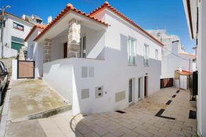 a white house with a courtyard at T3 São Martinho do Porto in São Martinho do Porto