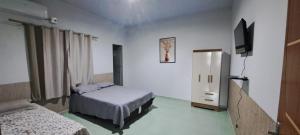 a bedroom with two beds and a television in it at Flat JM 05 in Parauapebas