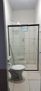 a bathroom with a toilet and a glass shower at Flat JM 05 in Parauapebas