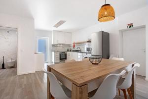 a kitchen and dining room with a wooden table and chairs at T3 São Martinho do Porto in São Martinho do Porto