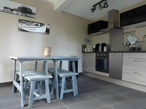 a kitchen with a blue table and stools at Maison Ô'5 Avec Terrasse in Lanton