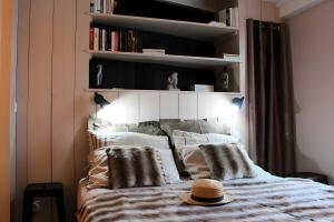 a bedroom with a bed with a hat on it at Maison Ô'5 Avec Terrasse in Lanton