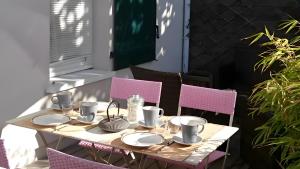 a table on a patio with pink chairs at Maison Ô'5 Avec Terrasse in Lanton +9 photos