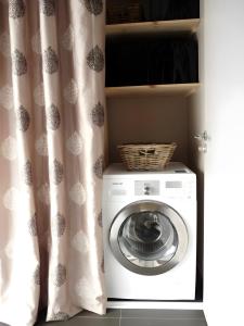 a washing machine in a room with a curtain at Maison Ô'5 Avec Terrasse in Lanton