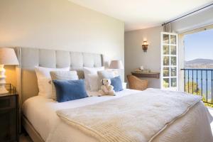 a teddy bear sitting on a bed in a bedroom at La Bastide d'Antoine in Saint-Tropez