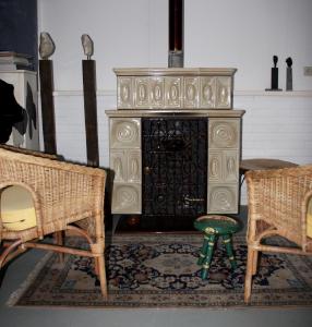 an old stove in a living room with two chairs at Atelier La Luna in Berkenwoude