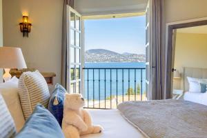 a teddy bear sitting on a bed in a bedroom at La Bastide d'Antoine in Saint-Tropez +63 photos