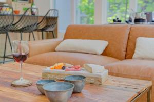 a wooden table with a glass of wine and a table with bowls at La Mi-Temps Spa - Relaxation & Private Spa in Pont-Rouge