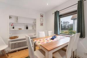 a dining room with a table and chairs and a window at Ferienwohnung Weyres in Fleckeby