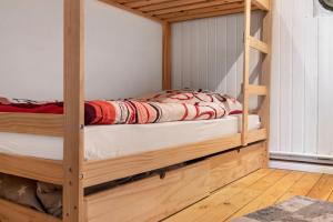 a wooden bunk bed in a room with wooden floors at Ferienwohnung Weyres in Fleckeby