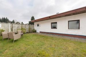 a backyard with two chairs and a fence at Ferienwohnung Weyres in Fleckeby