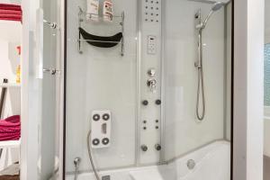 a shower with a glass door next to a tub at Ferienwohnung Weyres in Fleckeby +21 photos