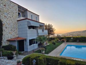 a house with a swimming pool in front of it at Villa Arena Theologos in Theologos