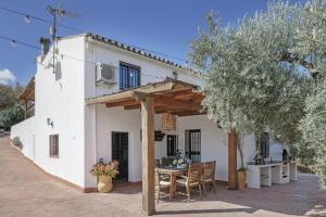 a white house with a table and chairs at El Puente Ronda in Ronda