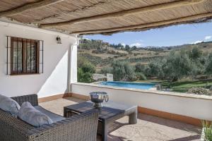 a patio with a table and chairs and a view at El Puente Ronda in Ronda