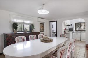 a kitchen and dining room with a white table and chairs at El Puente Ronda in Ronda
