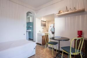 a bedroom with a bed and a table and chairs at Chez Lina - studio avec terrasse in Le Lavandou
