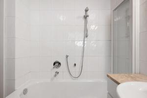 a white bathroom with a shower and a tub at Apartment Weber in Nova Levante +31 photos