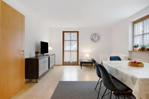 a living room with a table and chairs and a television at Apartment Weber in Nova Levante