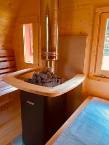 a stove in a log cabin with rocks in it at Casa Clus Bormio apartments 1 in Valdisotto +35 photos