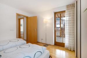 a bedroom with two beds and a large window at Apartment Weber in Nova Levante