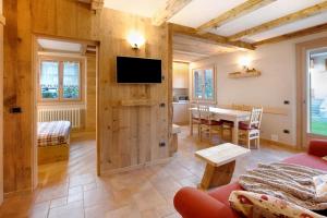 a living room with a couch and a tv on a wall at Casa Clus Bormio apartments 1 in Valdisotto