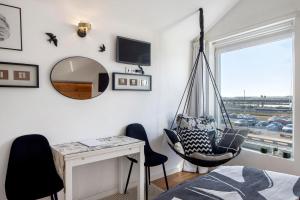 a bedroom with a hanging chair and a desk and a mirror at Salina Ria Studio in Aveiro