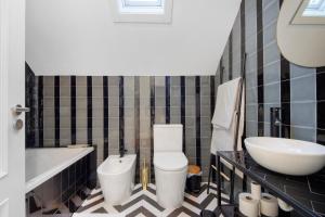 a bathroom with a toilet and a sink and a tub at Salina Ria Studio in Aveiro +14 photos