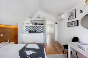 a white room with a bed and a desk at Salina Ria Studio in Aveiro