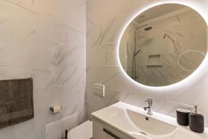 a white bathroom with a sink and a mirror at Casa Homem do Mar in Paul do Mar +18 photos
