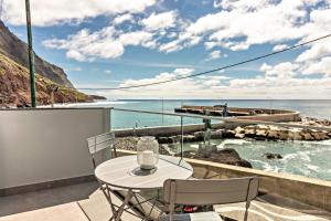 a balcony with a table and chairs overlooking the ocean at Casa Homem do Mar in Paul do Mar