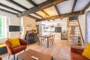 a kitchen and living room with a table and chairs at Les gîtes du logis in Saint-Romain-de-Benet