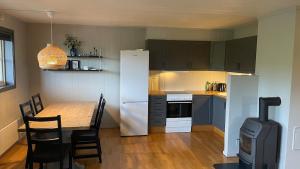 a kitchen with a table and a white refrigerator at Lemonsjøen, Jotunheimen in Vaga