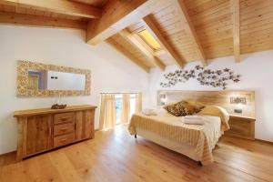 a bedroom with a large bed and a wooden ceiling at Villa Lice - Vigneto in Casarza Ligure