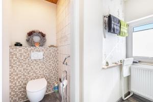 a bathroom with a toilet and a window at Fewo Mama Mia in Menden +21 photos