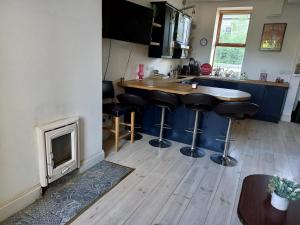 a kitchen with a bar with stools and a fireplace at Townhouse in Castleisland