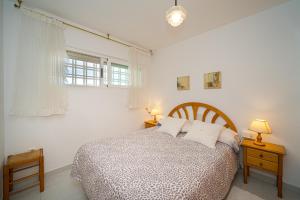 a bedroom with a bed with white walls and a window at Costa Bella in Altea +22 photos