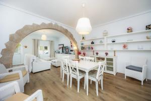 a dining room and living room with a white table and chairs at La Casita in Pollença