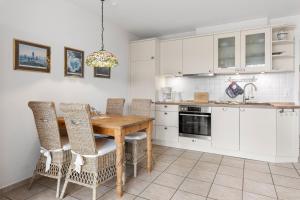 a kitchen with a wooden table and chairs at Deichblick in Böhl
