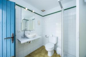 a white bathroom with a toilet and a sink at La Casita in Pollença +20 photos
