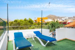 a patio with blue chairs and a table on a balcony at La Casita in Pollença