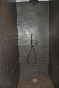 y baño alicatado con ducha y manguera. en Les Cîmes - Cosy apartment, en Val dʼIsère