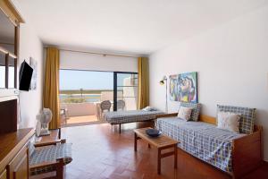 a living room with two couches and a balcony at Cabanas Mar 94 in Cabanas de Tavira