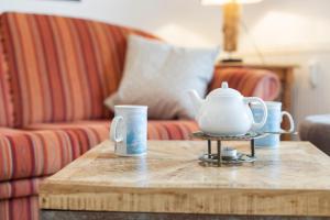 a coffee table with a tea pot and cups on it at Deichblick in Böhl