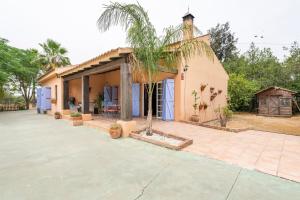 ein Haus mit einer Palme davor in der Unterkunft Villa Laforge in Carmona